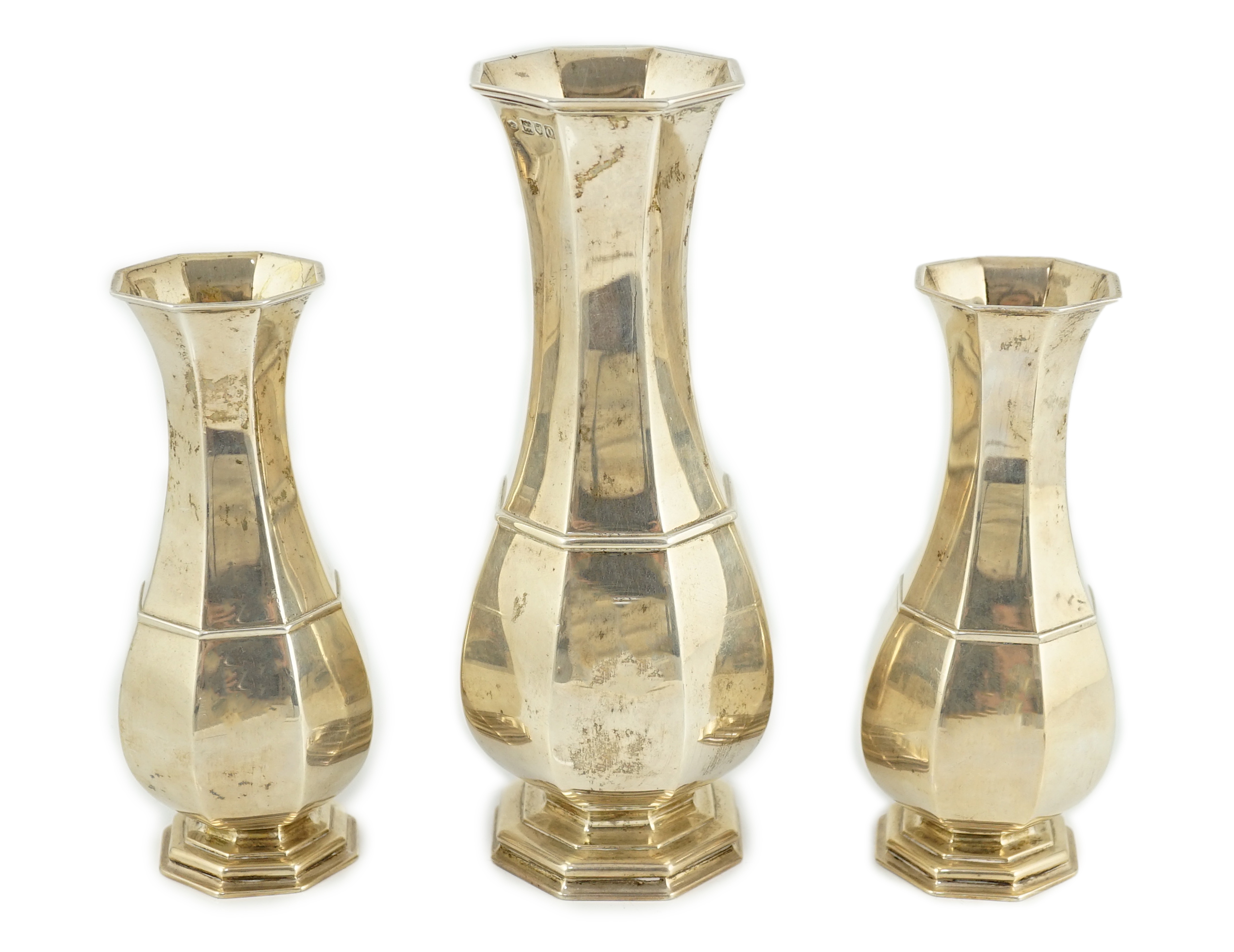 An Edwardian garniture of three panelled silver baluster vases by William Comyns